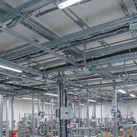 Generated scene of a cable tray grid under a factory ceiling